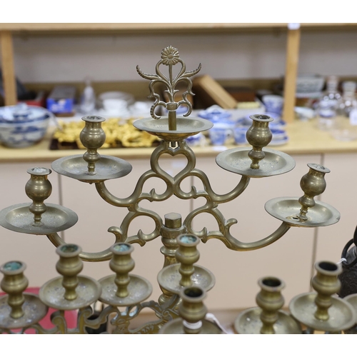 411 - Judaica - a pair of Polish brass candelabra and a similar larger candelabrum, tallest 63cm (3)... 