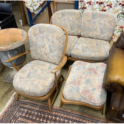 64 - An Ercol elm three piece suite comprising settee, armchair and footstool