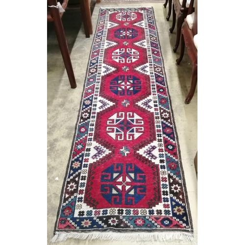 70 - A Caucasian style red ground runner, 274 x 72cm