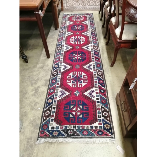 70 - A Caucasian style red ground runner, 274 x 72cm