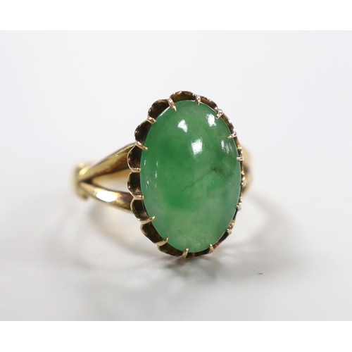 983 - A Chinese yellow metal and cabochon jade set oval ring, size Q/R, gross weight 5 grams.