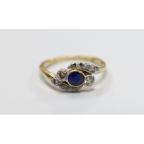 993 - An 18ct, single stone sapphire and two stone diamond crossover ring, with diamond set shoulders, siz... 