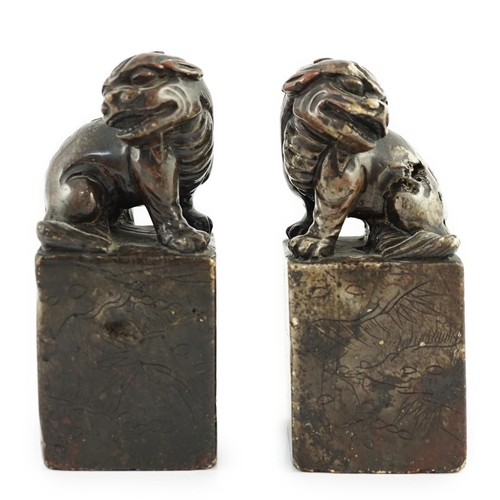 181 - A pair of Chinese soapstone lion-dog seals, Qing dynasty, with vacant matrices, the dark grey stone ... 