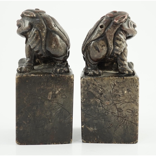 181 - A pair of Chinese soapstone lion-dog seals, Qing dynasty, with vacant matrices, the dark grey stone ... 