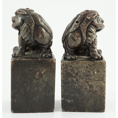 181 - A pair of Chinese soapstone lion-dog seals, Qing dynasty, with vacant matrices, the dark grey stone ... 