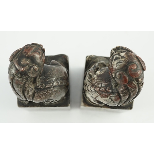 181 - A pair of Chinese soapstone lion-dog seals, Qing dynasty, with vacant matrices, the dark grey stone ... 