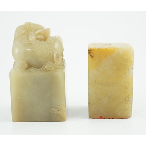 182 - Two Chinese soapstone seals, both of creamy green stone, the first surmounted by the figure of a lio... 