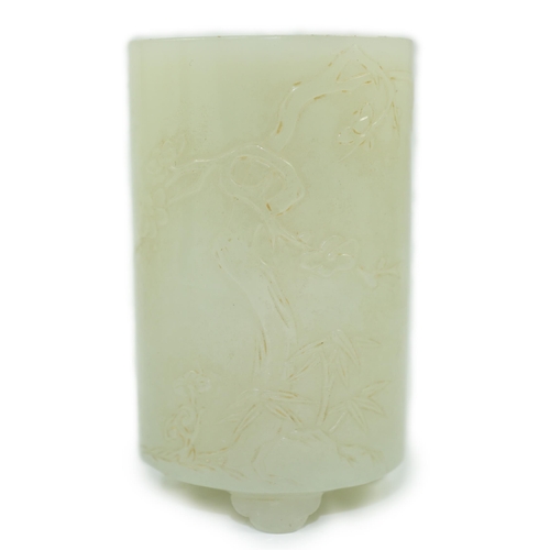 186 - A small Chinese pale celadon jade brushpot, 19th century, carved in relief with a blossoming plum tr... 