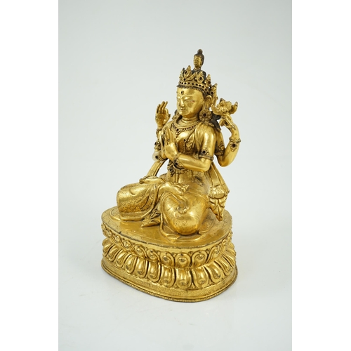 194 - A Sino-Tibetan gilt bronze figure of Shadakshari Lokeshvara, possibly 18th century, seated in vajrap... 