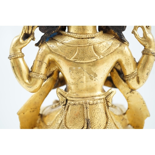 194 - A Sino-Tibetan gilt bronze figure of Shadakshari Lokeshvara, possibly 18th century, seated in vajrap... 