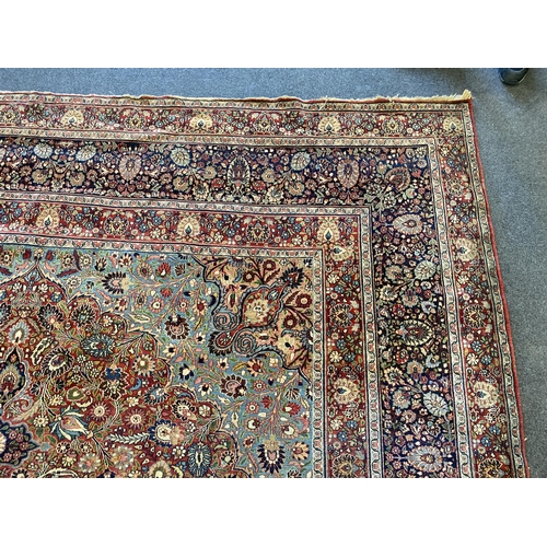 226 - A large Persian blue ground carpet, with central floral medallions radiating outwards to a palmette ... 