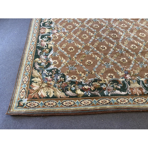 227 - A large Indian carpet, with foliate trellis ribbon and paterae motifs across a pale brown ground, wi... 