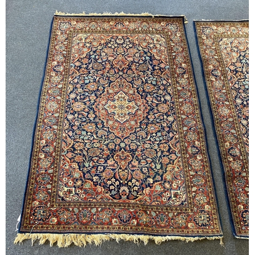 228 - A pair of Kashan blue ground rugs, with central medallions within stylised floral field, multi-borde... 