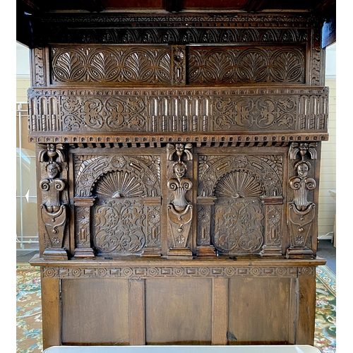 233 - A 17th century style oak tester bedstead, with gadrooned panelled canopy on cup and cover front colu... 