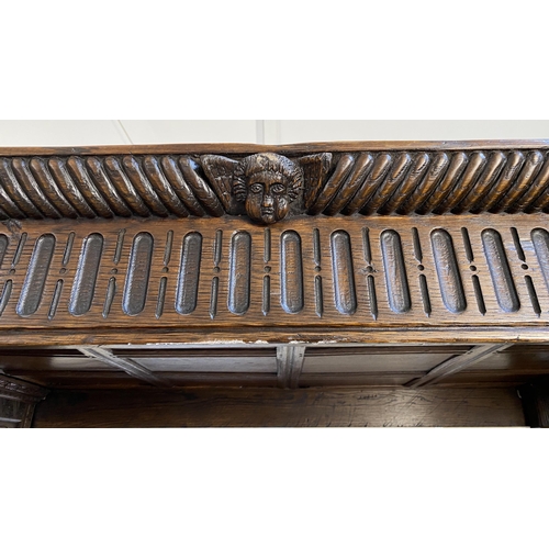 233 - A 17th century style oak tester bedstead, with gadrooned panelled canopy on cup and cover front colu... 