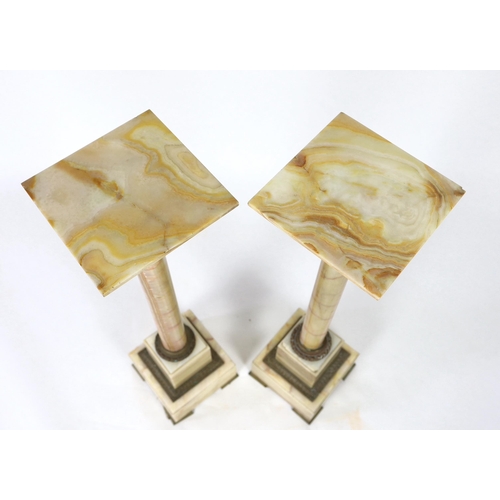 250 - A pair of early 20th century French ormolu mounted onyx pedestals, with revolving square tops, width... 