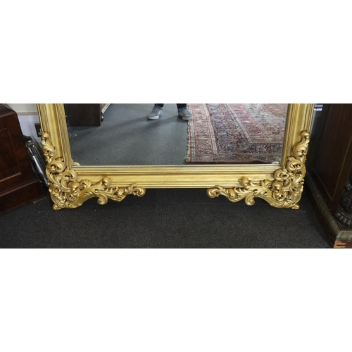 259 - An ornate early 20th century carved giltwood wall mirror, with elaborate foliate scroll work top inc... 