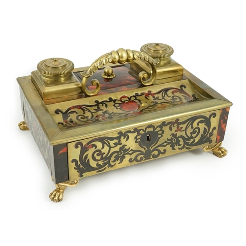 34 - A 19th century Louis XIV style red boulle inkstand, with loop handle, two brass wells and base drawe... 