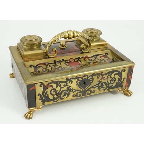 34 - A 19th century Louis XIV style red boulle inkstand, with loop handle, two brass wells and base drawe... 