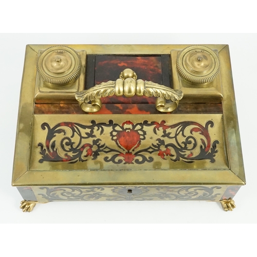 34 - A 19th century Louis XIV style red boulle inkstand, with loop handle, two brass wells and base drawe... 