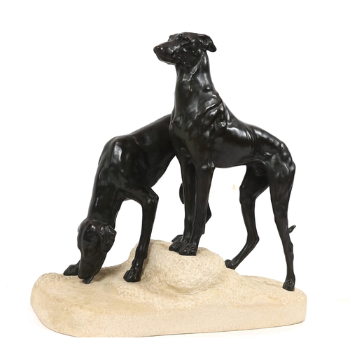 57 - Jules Edmund Masson (French, 1871-1932). A French Art Deco bronze group of two hounds, on naturalist... 