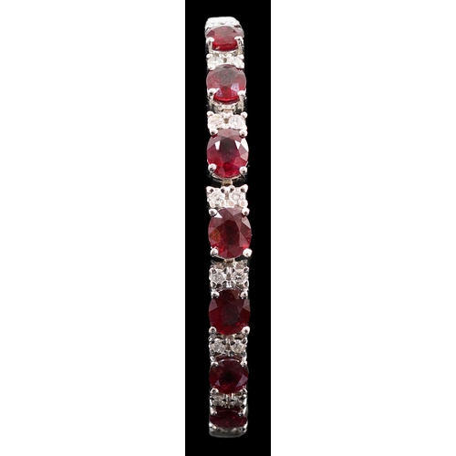 637 - A 750 white gold and seven stone oval cut ruby set line bracelet, set with sixteen stone diamond spa... 