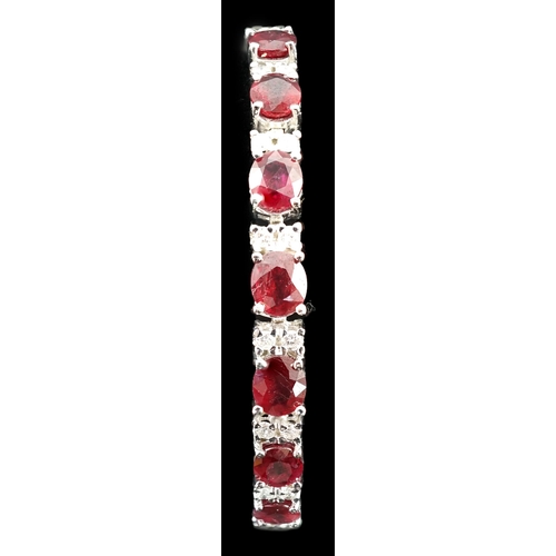 637 - A 750 white gold and seven stone oval cut ruby set line bracelet, set with sixteen stone diamond spa... 