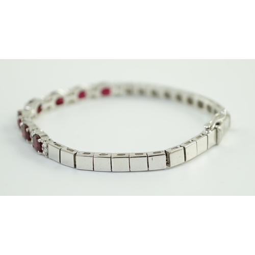 637 - A 750 white gold and seven stone oval cut ruby set line bracelet, set with sixteen stone diamond spa... 