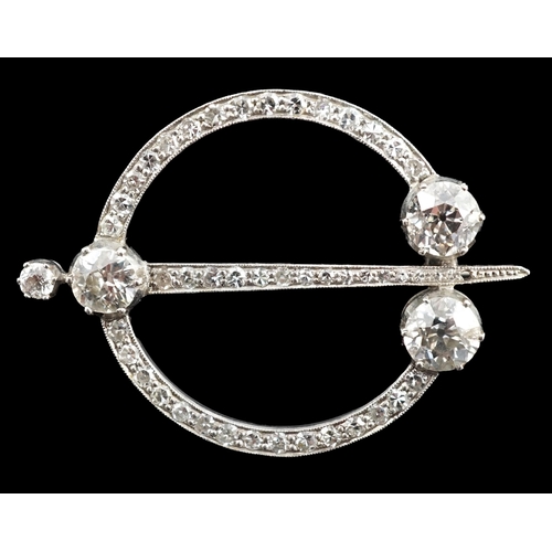 648 - A 1920's platinum or white gold, diamond cluster set openwork 'dagger and circle' brooch, set with c... 