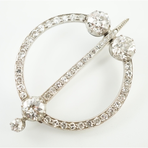 648 - A 1920's platinum or white gold, diamond cluster set openwork 'dagger and circle' brooch, set with c... 