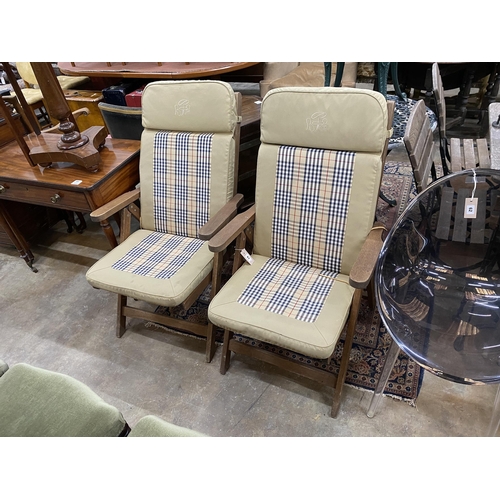 16 - A pair of teak reclining garden elbow chairs with cushions, width 60cm, height 100cm