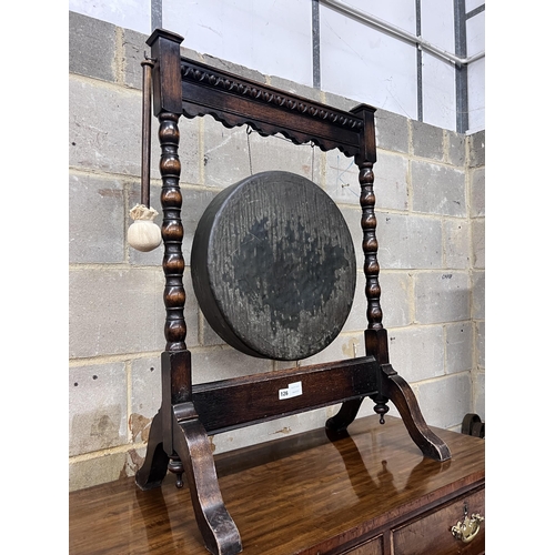 126 - An early 20th century oak dinner gong with striker, width 68cm, height 99cm