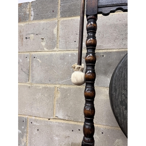 126 - An early 20th century oak dinner gong with striker, width 68cm, height 99cm