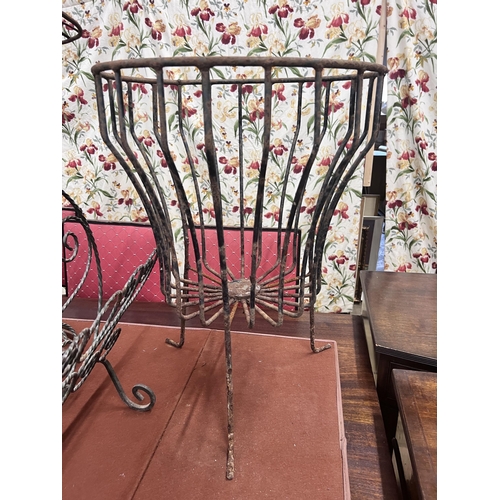 24 - A pair of wrought iron circular garden frames, a magazine rack and a copper cauldron, largest height... 