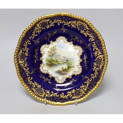 264 - A Coalport gadroon-rimmed plate with elaborated blue and gilt border, painted with a central landsca... 