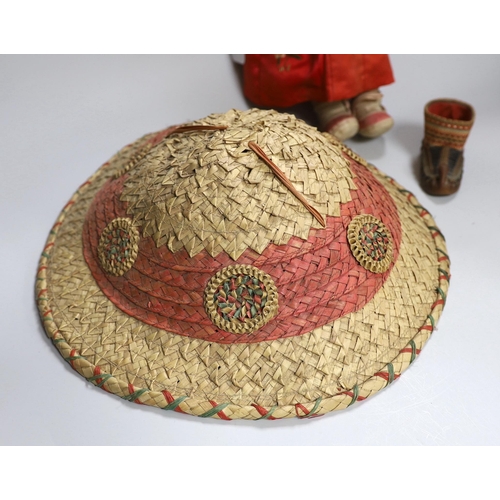 308 - A composition Burmese doll, 40cm, related hat and a shoe