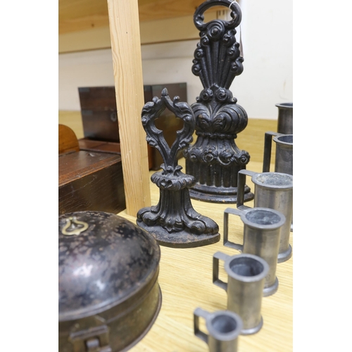 424 - A graduated set of seven French pewter measures, a toleware spice box and two cast iron door stops (... 