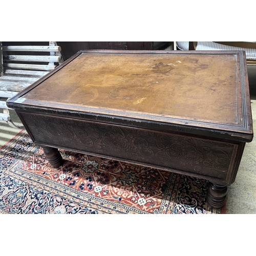 87 - A rectangular embossed leather covered mahogany coffee table on turned feet, incorporates old timber... 