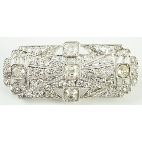 901 - An Art Deco pierced platinum and millegrain set diamond cluster shaped rectangular brooch, set with ... 