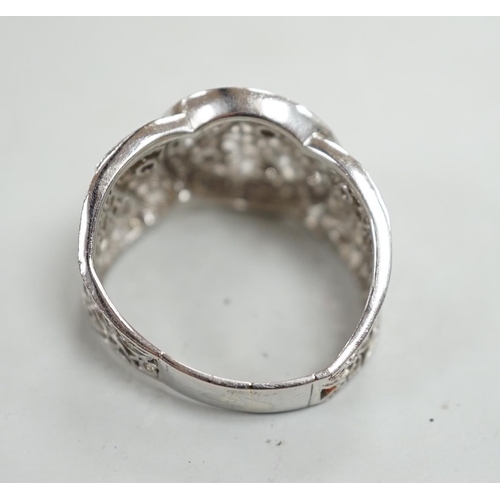 911 - A pierced white metal and diamond chip set diamond ring, with scrolling decoration, size Q/R, gross ... 