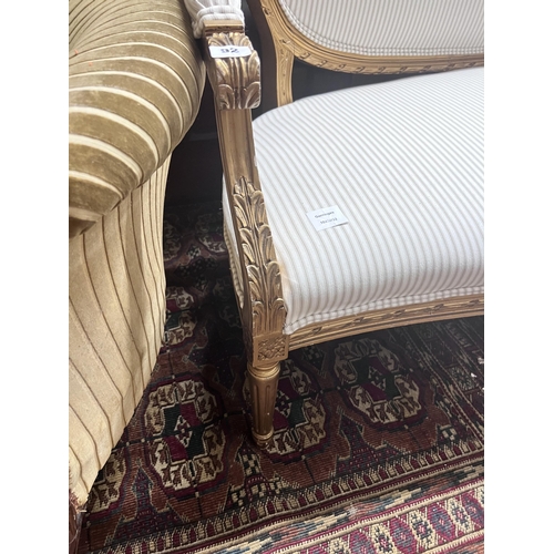 92 - A French giltwood and composition settee, recently re-upholstered in a striped linen fabric, width 1... 