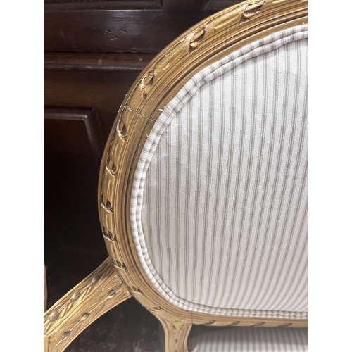 92 - A French giltwood and composition settee, recently re-upholstered in a striped linen fabric, width 1... 