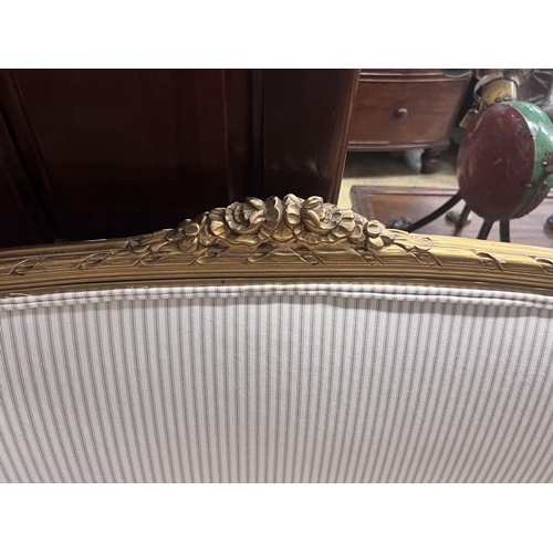 92 - A French giltwood and composition settee, recently re-upholstered in a striped linen fabric, width 1... 