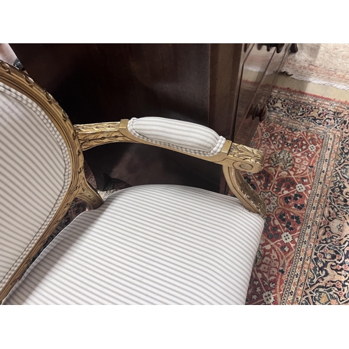 92 - A French giltwood and composition settee, recently re-upholstered in a striped linen fabric, width 1... 