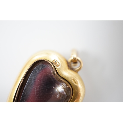 921 - A late Victorian yellow metal (stamped 18) and cabochon garnet set heart shaped pendant, with glazed... 