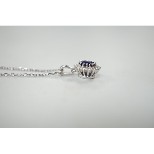 932 - A modern 9ct white gold, sapphire and diamond set oval cluster pendant, overall 15mm,on a modern 9ct... 