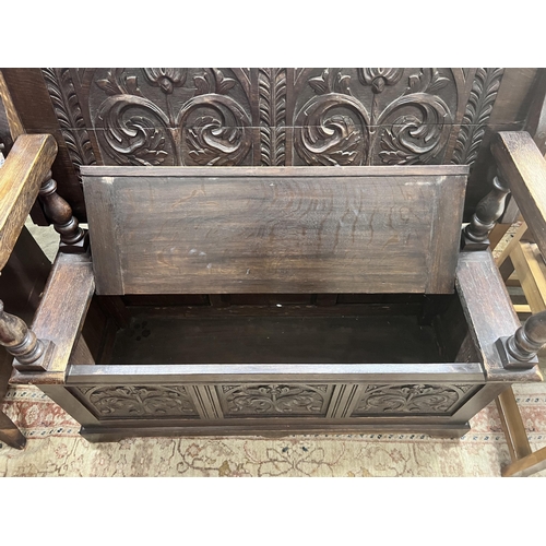 94 - A 1920s carved oak monk's bench, width 122cm, depth 51cm, height 78cm