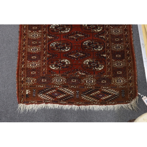 1166 - A Turkeman burgundy ground rug, 126 x 94cm