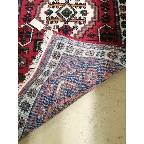 1024 - A Caucasian style red ground rug, 130cm x 68cm