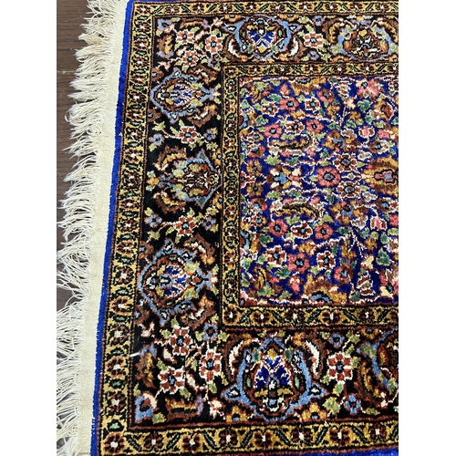 1038 - A North West Persian part silk blue ground rug, 89cm x 58cm